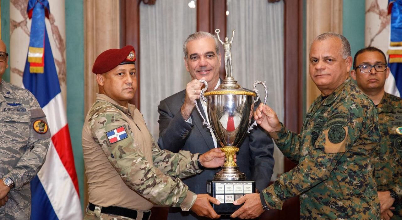 Abinader recibe y felicita a campeones dominicanos de Fuerza Comando Paraguay 2026 durante visita en el Palacio Nacional En el Foco Gobierno. El presidente Luis Abinader recibió este jueves en el Palacio Nacional a los integrantes del equipo dominicano de Fuerzas Especiales que conquistó el primer lugar en la competencia internacional Fuerza Comando Paraguay 2026, alcanzando un resultado histórico para la República Dominicana y sus Fuerzas Armadas. Durante el encuentro, celebrado en el Salón Embajadores, el jefe de Estado felicitó personalmente a los miembros del equipo y aseguró que hoy puede decirse que el “país pasó de la retaguardia a la vanguardia”. “Nuestras Fuerzas Armadas, este pequeño país, pero grande en deseo de progresar, de innovar, gana entonces la competencia de las Fuerzas Élites”, expresó el mandatario. El jefe de Estado anunció que los militares serán ascendidos el próximo 27 de febrero, como reconocimiento a su desempeño, su destacada participación y al primer lugar obtenido por la República Dominicana en este evento internacional. Asimismo, el gobernante destacó el proceso de transformación y fortalecimiento que han experimentado las Fuerzas Armadas dominicanas, al resaltar que el país alcanzó, por primera vez, el primer lugar en una competencia internacional de Fuerzas de Comando, por encima de Colombia y Estados Unidos. En ese sentido, el mandatario atribuyó estos avances a las inversiones realizadas en infraestructura, equipamiento, entrenamiento e innovación en el Ejército, la Armada y la Fuerza Aérea, así como al desarrollo de la industria militar dominicana. El presidente Abinader resaltó que esta industria ha permitido al país avanzar de ser un comprador de equipos militares a desarrollar y exportar productos de fabricación nacional, entre ellos vehículos blindados y ambulancias. “Sin unas Fuerzas Armadas fuertes, no hay un país fuerte”, afirmó el presidente, al señalar que estos avances contribuyen a fortalecer la protección del territorio, la integridad nacional y las fronteras. Hazaña de soldados dominicanos tras conquistar primer lugar en Fuerza Comando Paraguay 2026 De su lado, el ministro de Defensa, teniente general Carlos Antonio Fernández Onofre, destacó el histórico triunfo de la delegación dominicana en la competencia Fuerza Comando Paraguay 2026, donde el país alcanzó el primer lugar entre 17 naciones del continente americano. El ministro sostuvo que esta hazaña demuestra que la República Dominicana cuenta con soldados preparados para enfrentar los desafíos más exigentes, con profesionalismo, determinación y profundo sentido patriótico, al destacar que esta es la primera vez que las Fuerzas Armadas dominicanas conquistan esta competencia, tras 22 años de existencia, y atribuyó el logro a la disciplina, preparación, trabajo en equipo y profesionalismo de los soldados. “Como ministro de Defensa, expreso públicamente que estos soldados son un ejemplo de la preparación constante, calidad humana y profesional que estamos forjando en nuestras Fuerzas Armadas”, manifestó Fernández Onofre. El ministro de Defensa agradeció al presidente Luis Abinader el respaldo brindado al proceso de fortalecimiento, modernización, tecnificación, desarrollo industrial, profesionalización y equipamiento de las instituciones militares, al tiempo que afirmó que el triunfo alcanzado es también resultado de los avances logrados durante los seis años de gestión de Gobierno. Fuente de orgullo y motivación para todos los miembros de las Fuerzas Armadas El primer lugar obtenido en Fuerza Comando Paraguay 2026 constituye, además, una fuente de orgullo y motivación para todos los miembros de las Fuerzas Armadas y un compromiso para continuar elevando los estándares de preparación, disciplina y excelencia de las instituciones militares dominicanas. La conquista del primer lugar evidencia los elevados niveles de preparación física, táctica y operacional alcanzados por las unidades especializadas de las Fuerzas Armadas, como resultado de un proceso continuo de entrenamiento, profesionalización, actualización doctrinal y fortalecimiento de sus capacidades. Asimismo, este histórico triunfo refleja los avances que experimentan las instituciones militares como parte del proceso de modernización y actualización de equipos y capacidades impulsado por el Gobierno del presidente Luis Abinader, a través del Ministerio de Defensa, con el propósito de fortalecer la preparación y capacidad operacional de los hombres y mujeres responsables de la defensa y seguridad de la nación. El encuentro con el presidente Abinader representó un reconocimiento al esfuerzo colectivo de los soldados, sus instructores, comandantes, unidades militares y familiares, cuyo respaldo fue fundamental en el proceso de preparación que culminó con la histórica victoria alcanzada en Paraguay. Con este resultado, la República Dominicana fortalece su prestigio en el ámbito militar internacional y reafirma el alto nivel profesional de sus Fuerzas Especiales, demostrando su capacidad para competir exitosamente frente a unidades élite de naciones amigas. Los campeones estuvieron acompañados por el ministro de Defensa, teniente general Carlos Antonio Fernández Onofre, ERD., junto a los comandantes generales del Ejército de República Dominicana, mayor general Jimmy Arias Grullón y de la Fuerza Aérea de República Dominicana, mayor general piloto Enmanuel Marcelino Souffront Tamayo, así como el subcomandante general de la Armada de República Dominicana, Anthony Manuel Tadeo Jiminián Objío. Abinader recibe y felicita a campeones dominicanos de Fuerza Comando Paraguay 2026 durante visita en el Palacio Nacional En el Foco Gobierno. El presidente Luis Abinader recibió este jueves en el Palacio Nacional a los integrantes del equipo dominicano de Fuerzas Especiales que conquistó el primer lugar en la competencia internacional Fuerza Comando Paraguay 2026, alcanzando un resultado histórico para la República Dominicana y sus Fuerzas Armadas. Durante el encuentro, celebrado en el Salón Embajadores, el jefe de Estado felicitó personalmente a los miembros del equipo y aseguró que hoy puede decirse que el “país pasó de la retaguardia a la vanguardia”. “Nuestras Fuerzas Armadas, este pequeño país, pero grande en deseo de progresar, de innovar, gana entonces la competencia de las Fuerzas Élites”, expresó el mandatario. El jefe de Estado anunció que los militares serán ascendidos el próximo 27 de febrero, como reconocimiento a su desempeño, su destacada participación y al primer lugar obtenido por la República Dominicana en este evento internacional. Asimismo, el gobernante destacó el proceso de transformación y fortalecimiento que han experimentado las Fuerzas Armadas dominicanas, al resaltar que el país alcanzó, por primera vez, el primer lugar en una competencia internacional de Fuerzas de Comando, por encima de Colombia y Estados Unidos. En ese sentido, el mandatario atribuyó estos avances a las inversiones realizadas en infraestructura, equipamiento, entrenamiento e innovación en el Ejército, la Armada y la Fuerza Aérea, así como al desarrollo de la industria militar dominicana. El presidente Abinader resaltó que esta industria ha permitido al país avanzar de ser un comprador de equipos militares a desarrollar y exportar productos de fabricación nacional, entre ellos vehículos blindados y ambulancias. “Sin unas Fuerzas Armadas fuertes, no hay un país fuerte”, afirmó el presidente, al señalar que estos avances contribuyen a fortalecer la protección del territorio, la integridad nacional y las fronteras. Hazaña de soldados dominicanos tras conquistar primer lugar en Fuerza Comando Paraguay 2026 De su lado, el ministro de Defensa, teniente general Carlos Antonio Fernández Onofre, destacó el histórico triunfo de la delegación dominicana en la competencia Fuerza Comando Paraguay 2026, donde el país alcanzó el primer lugar entre 17 naciones del continente americano. El ministro sostuvo que esta hazaña demuestra que la República Dominicana cuenta con soldados preparados para enfrentar los desafíos más exigentes, con profesionalismo, determinación y profundo sentido patriótico, al destacar que esta es la primera vez que las Fuerzas Armadas dominicanas conquistan esta competencia, tras 22 años de existencia, y atribuyó el logro a la disciplina, preparación, trabajo en equipo y profesionalismo de los soldados. “Como ministro de Defensa, expreso públicamente que estos soldados son un ejemplo de la preparación constante, calidad humana y profesional que estamos forjando en nuestras Fuerzas Armadas”, manifestó Fernández Onofre. El ministro de Defensa agradeció al presidente Luis Abinader el respaldo brindado al proceso de fortalecimiento, modernización, tecnificación, desarrollo industrial, profesionalización y equipamiento de las instituciones militares, al tiempo que afirmó que el triunfo alcanzado es también resultado de los avances logrados durante los seis años de gestión de Gobierno. Fuente de orgullo y motivación para todos los miembros de las Fuerzas Armadas El primer lugar obtenido en Fuerza Comando Paraguay 2026 constituye, además, una fuente de orgullo y motivación para todos los miembros de las Fuerzas Armadas y un compromiso para continuar elevando los estándares de preparación, disciplina y excelencia de las instituciones militares dominicanas. La conquista del primer lugar evidencia los elevados niveles de preparación física, táctica y operacional alcanzados por las unidades especializadas de las Fuerzas Armadas, como resultado de un proceso continuo de entrenamiento, profesionalización, actualización doctrinal y fortalecimiento de sus capacidades. Asimismo, este histórico triunfo refleja los avances que experimentan las instituciones militares como parte del proceso de modernización y actualización de equipos y capacidades impulsado por el Gobierno del presidente Luis Abinader, a través del Ministerio de Defensa, con el propósito de fortalecer la preparación y capacidad operacional de los hombres y mujeres responsables de la defensa y seguridad de la nación. El encuentro con el presidente Abinader representó un reconocimiento al esfuerzo colectivo de los soldados, sus instructores, comandantes, unidades militares y familiares, cuyo respaldo fue fundamental en el proceso de preparación que culminó con la histórica victoria alcanzada en Paraguay. Con este resultado, la República Dominicana fortalece su prestigio en el ámbito militar internacional y reafirma el alto nivel profesional de sus Fuerzas Especiales, demostrando su capacidad para competir exitosamente frente a unidades élite de naciones amigas. Los campeones estuvieron acompañados por el ministro de Defensa, teniente general Carlos Antonio Fernández Onofre, ERD., junto a los comandantes generales del Ejército de República Dominicana, mayor general Jimmy Arias Grullón y de la Fuerza Aérea de República Dominicana, mayor general piloto Enmanuel Marcelino Souffront Tamayo, así como el subcomandante general de la Armada de República Dominicana, Anthony Manuel Tadeo Jiminián Objío.