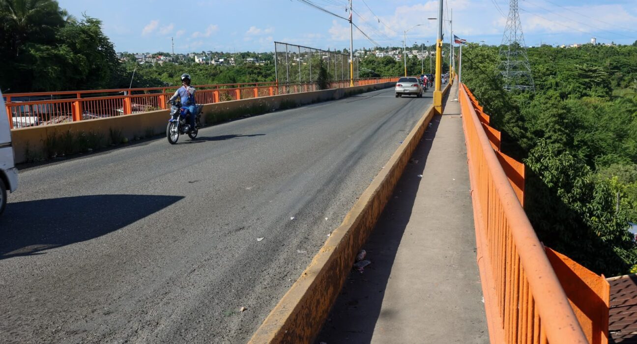 Anuncian restricciones de vehículos pesados en el puente de Sabana Perdida, para su segunda fase de mantenimiento En el Foco Nacional. El Ministerio de Obras Públicas y Comunicaciones (MOPC) iniciará la segunda fase de mantenimiento y reforzamiento preventivo en el puente Gregorio Luperón (La Barquita), como parte del programa nacional de inspección vial para preservar la seguridad de los usuarios y la durabilidad de la estructura. Durante la primera fase el puente ha sido sometido a rigurosas mejoras en los tramos que componen los extremos, también en este periodo se realizó inspección del tramo central. En la segunda fase se realizará mantenimiento y reforzamiento del tramo central. Para garantizar la seguridad durante el proceso, en coordinación con INTRANT, DIGESSET y COMIPOL se ejecutará el siguiente esquema de tránsito: Medidas de circulación y restricciones: * Tránsito pesado: Suspendido totalmente a partir del 20 de octubre hasta nuevo aviso. * Vehículos livianos: * Lunes a viernes: Cierre de 10:00 p.m. a 5:00 a. m. * Fines de semana: Cierre total desde el sábado a las 1:00 p. m. hasta el lunes a las 5:00 a. m. * Motocicletas y peatones: Se permitirá la circulación de motores y peatones. Con esta intervención, el MOPC busca prolongar la vida útil de un puente esencial para la conexión entre comunidades del Gran Santo Domingo. Las restricciones temporales permitirán avanzar en los trabajos con mayor seguridad para quienes transitan por la estructura y para el personal que realiza las labores.